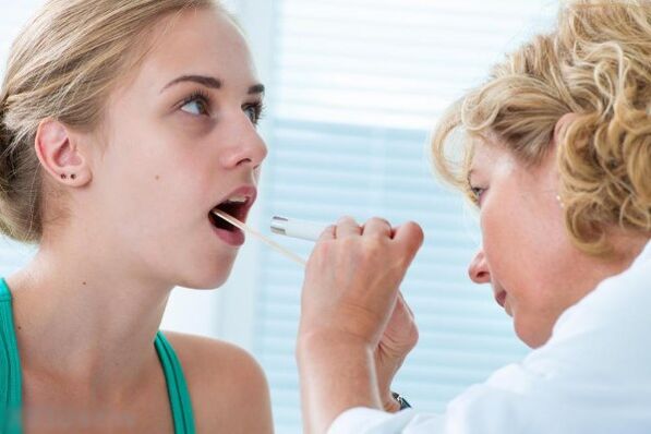 Zdravnik pregleda ustno votlino za prisotnost papiloma